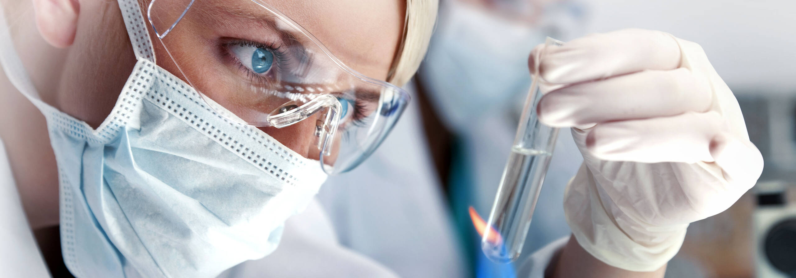 Labormitarbeiterin schaut sich Reagenzglas an